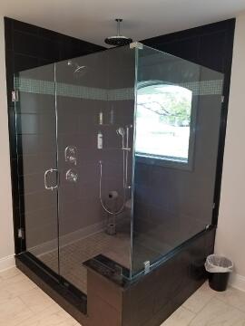 Corner glass shower enclosure with swing door installed by Great Lakes Glass in Cleveland, Ohio