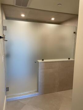 Frosted frameless glass shower enclosure with knob style custom glass shower door, installed by Great Lakes Glass in Cleveland, Ohio