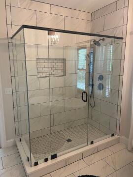 Black framed glass shower enclosure with swing style custom glass shower door, installed by Great Lakes Glass in Cleveland, Ohio